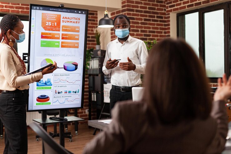 african-american-entrepreneurs-showing-management-presentation-explaining-business-graphs-working-company-partnership-startup-office-businessteam-with-medical-face-mask-against-covid19_482257-34963