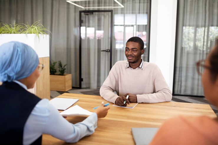 man-sitting-down-office-job-interview-desk-with-his-employers_23-2149034561